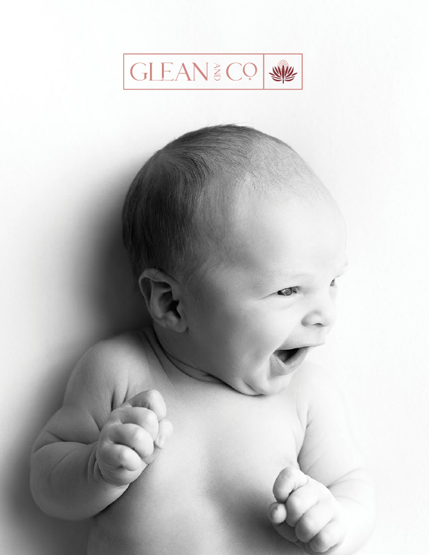 Black and white portrait of a smiling newborn baby on a client welcome guide cover