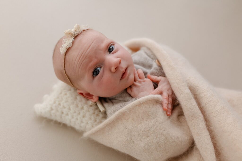 A skeptical baby with a wrinkled forehead gives a questioning look, as if wondering how to get more photography clients - perfectly capturing every photographer's mood when staring at an empty inbox